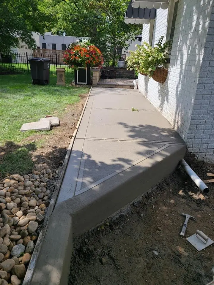 New concrete sidewalk poured alongside a home